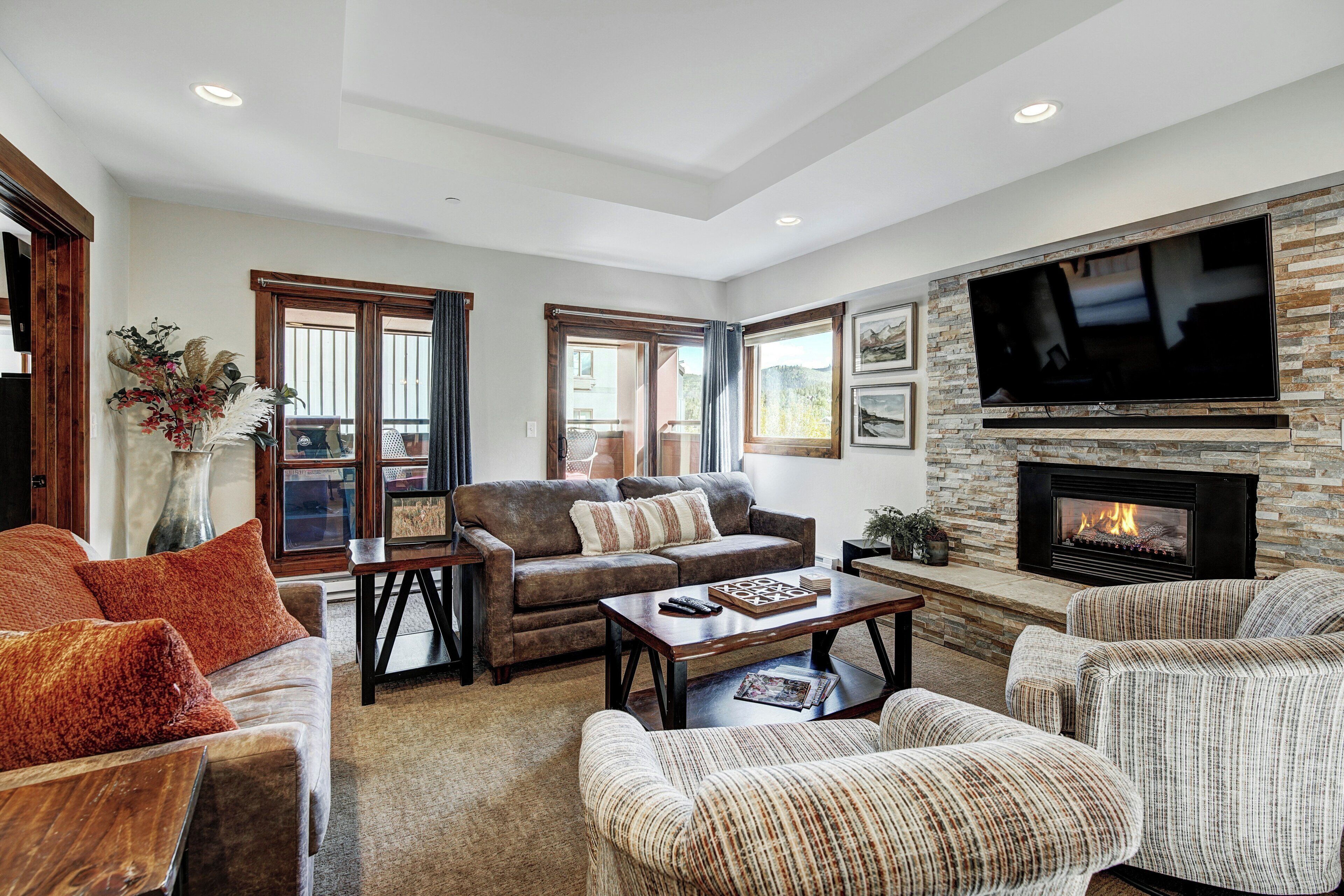 A living room with a fireplace, sofas, and a television.