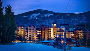 A multi-story hotel with a clock tower, ski lift, and mountainous backdrop. - Village at Breckenridge, A Vail Resorts Property (Breckenridge)