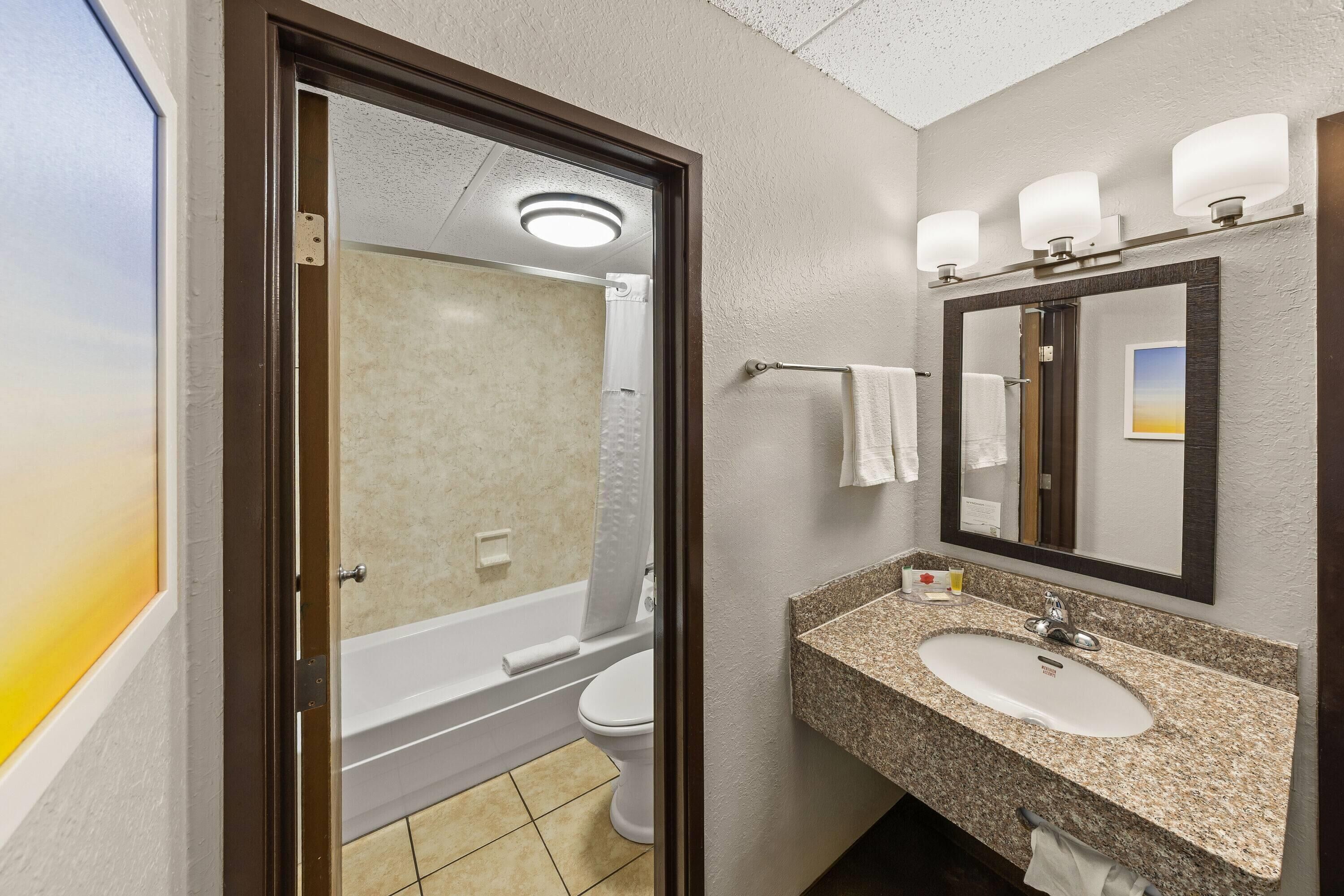 Une salle de bain équipée d’un lavabo, d’un miroir et d’un espace douche.