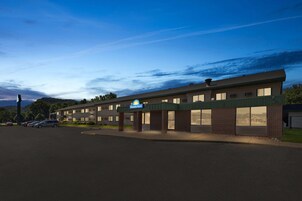 Un Days Inn con un diseño sencillo y funcional, que cuenta con techo plano, aparcamiento y una vista despejada del paisaje circundante.