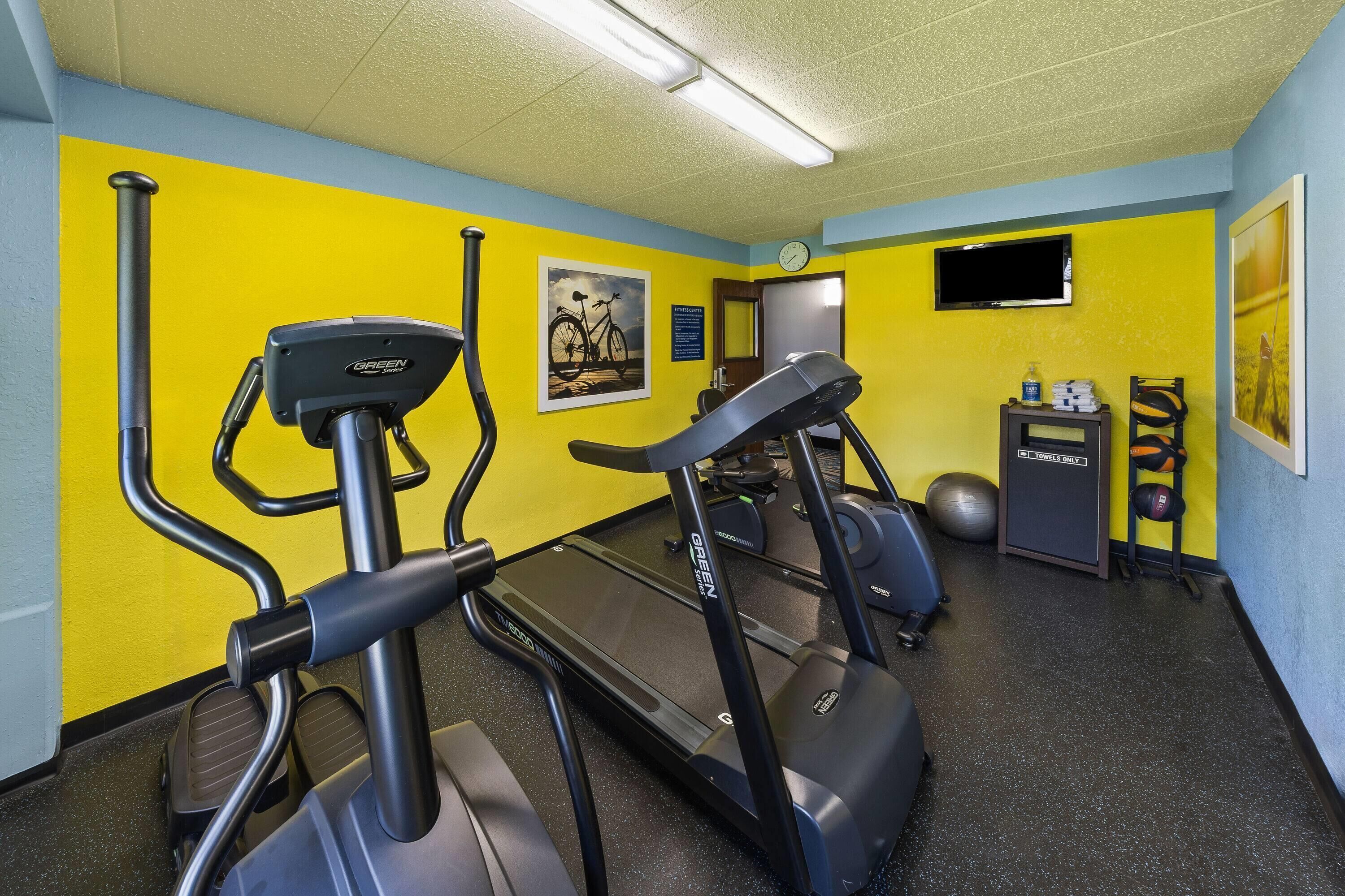 A gym with treadmills, a stationary bike, and a rowing machine.