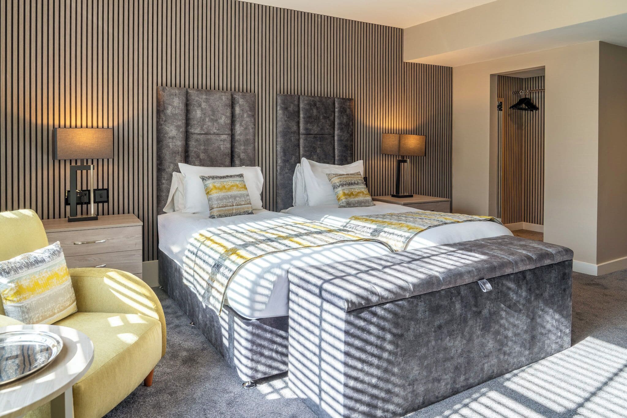 Et moderne hotelværelse med en stor seng, to sengeborde, en sofa og et klædeskab.