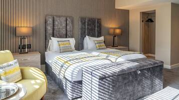Ein modernes Hotelzimmer mit einem großen Bett, zwei Nachttischen, einer Couch und einem Kleiderschrank.