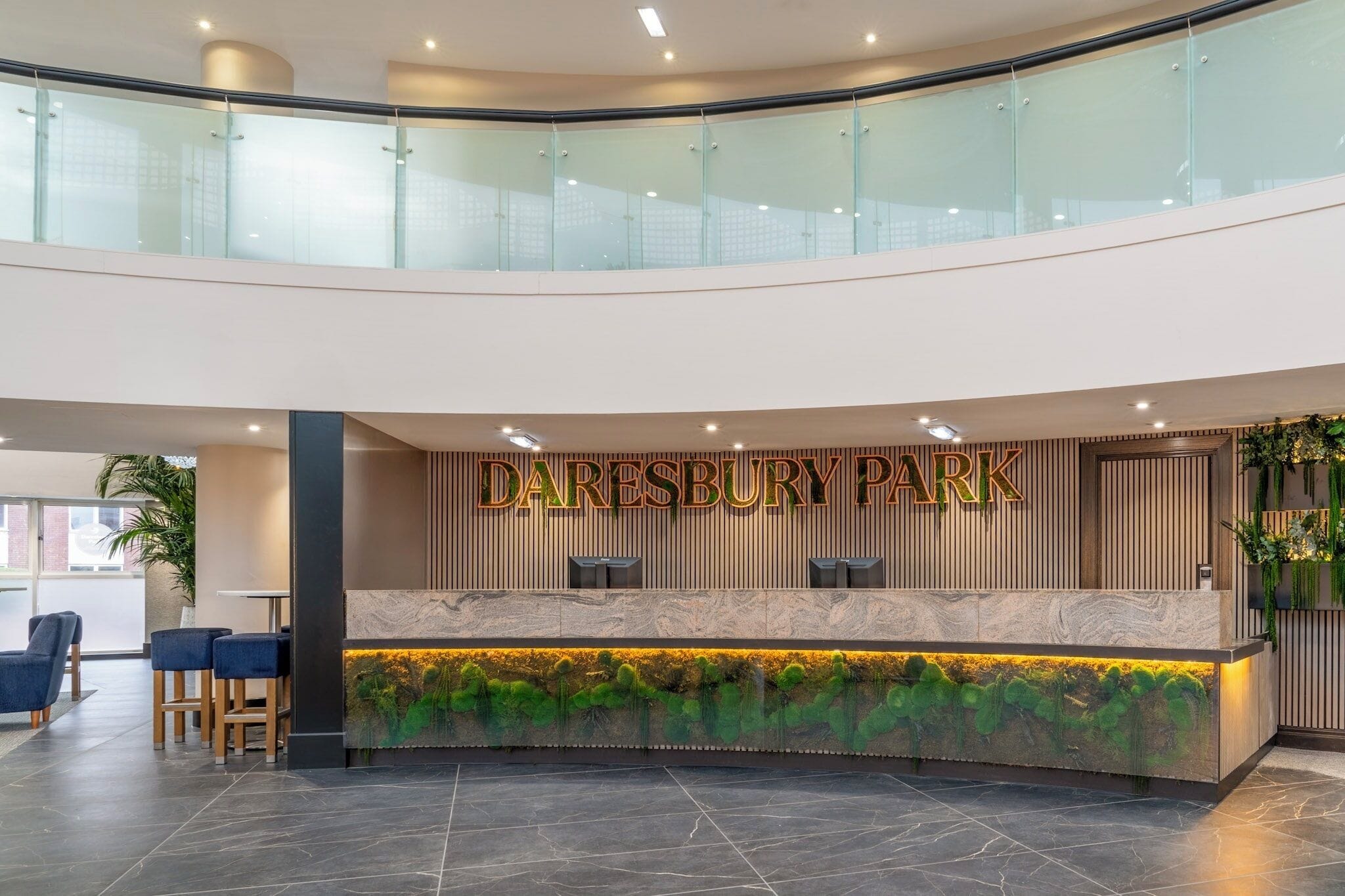 A reception area with a marble counter, glass railings, and a sign that reads "DARESBURY PARK".