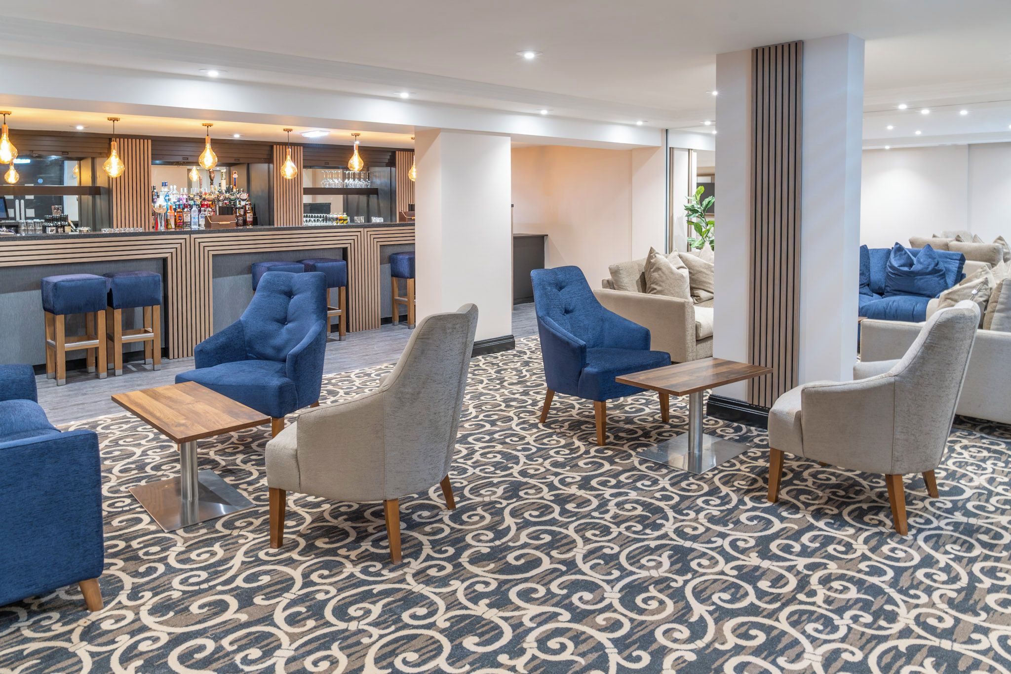 A modern lounge area with seating and a bar.