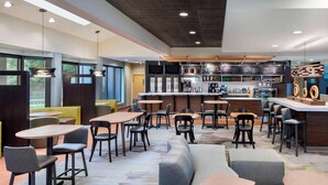 A modern cafe with multiple seating options including tables, chairs, and sofas.