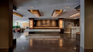 A spacious lobby with a marble reception desk, recessed lighting, and a large abstract artwork on the wall. - The Dupont Circle Hotel (Washington)