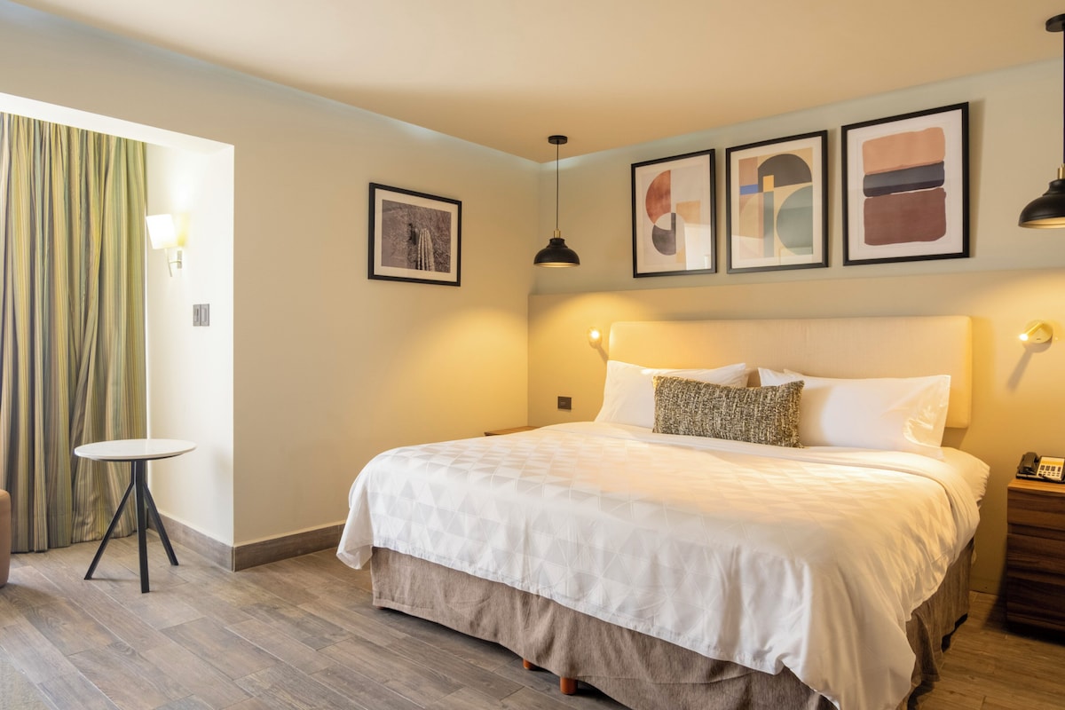 A bedroom with a bed, a round table, and a curtain.