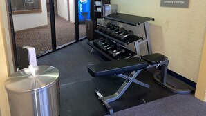 A fitness center with exercise equipment, a water dispenser, and a sign indicating it is part of Clarion Get Fit. - Clarion Inn (Merrillville)