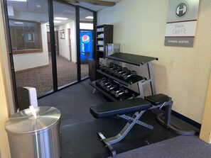 A fitness center with exercise equipment, a water dispenser, and a sign indicating it is part of Clarion Get Fit. - Clarion Inn (Merrillville)
