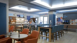 Un café moderne doté d’un espace salon, d’un comptoir et d’une signalétique bien visible.