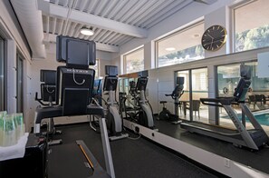 Een sportschool met loopbanden, elliptische trainers en hometrainers.