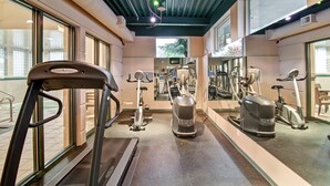 Un gimnasio con cintas de correr, bicicletas estáticas y elípticas.