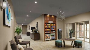 A modern lobby with seating, a snack bar, and a vending machine. - Residence Inn by Marriott Arlington (Arlington)