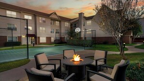 An outdoor patio area with a fire pit, seating, and a basketball court. - Residence Inn by Marriott Arlington (Arlington)