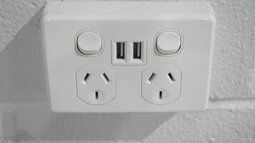A white electrical outlet with two USB ports and two standard outlets.
