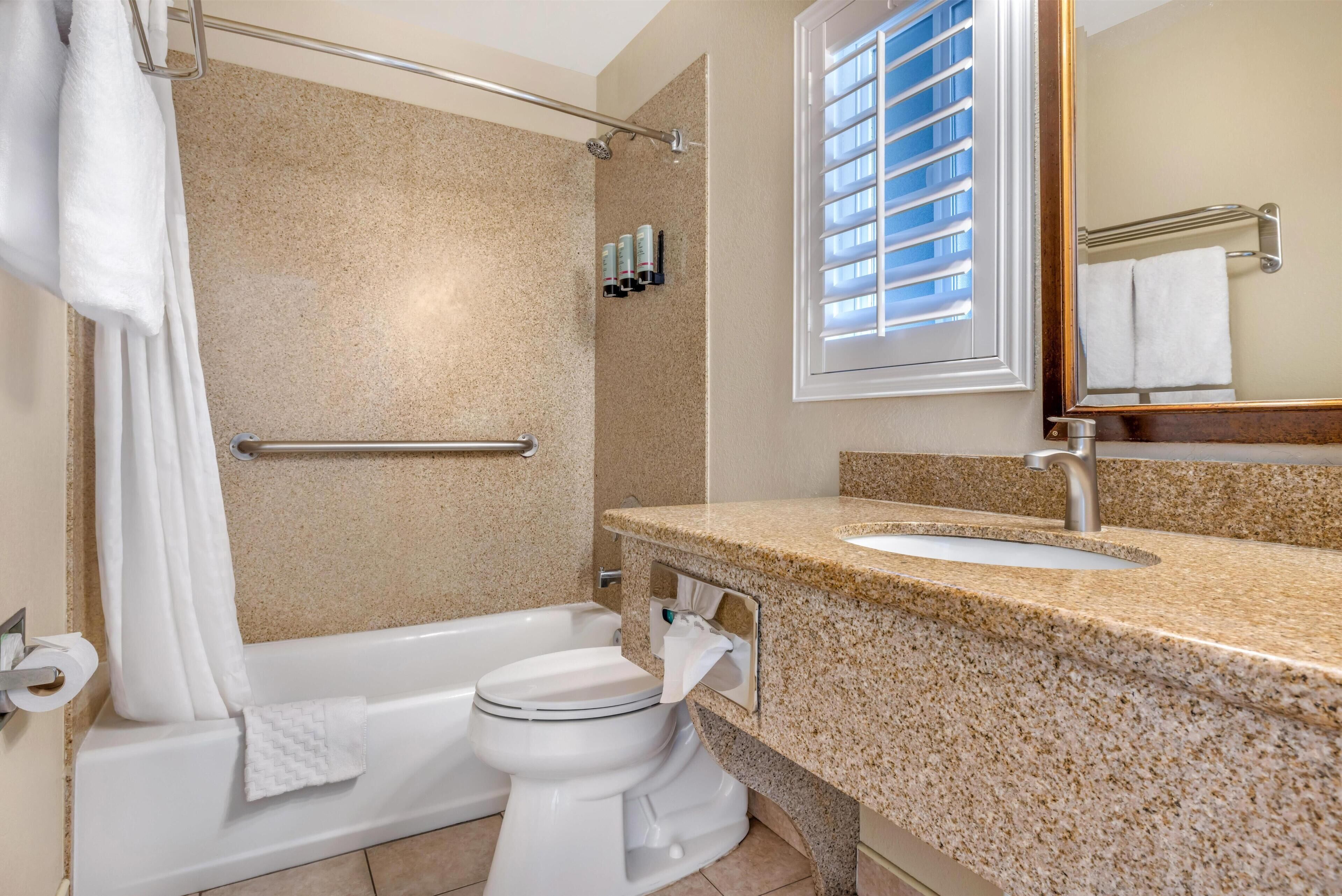 A bathroom with a bathtub, toilet, sink, and shower.