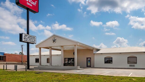 A Red Roof Inn with a covered parking area and a clear sky. - Red Roof Inn Nacogdoches (Nacogdoches)