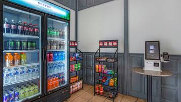 A beverage cooler stocked with various drinks, a snack shelf, and a self-service kiosk.