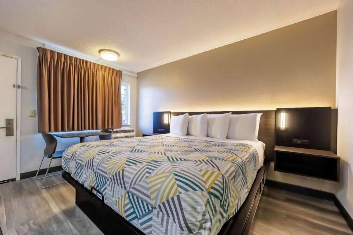 Une chambre d’hôtel moderne, dotée d’un grand lit, d’un bureau et d’une chaise.