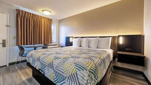 A modern hotel room with a large bed, a desk, and a chair. - Motel 6 Portland, OR - Southeast (Portland)