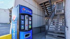 A Pepsi vending machine next to a building with a staircase. - Motel 6 Portland, OR - Southeast (Portland)