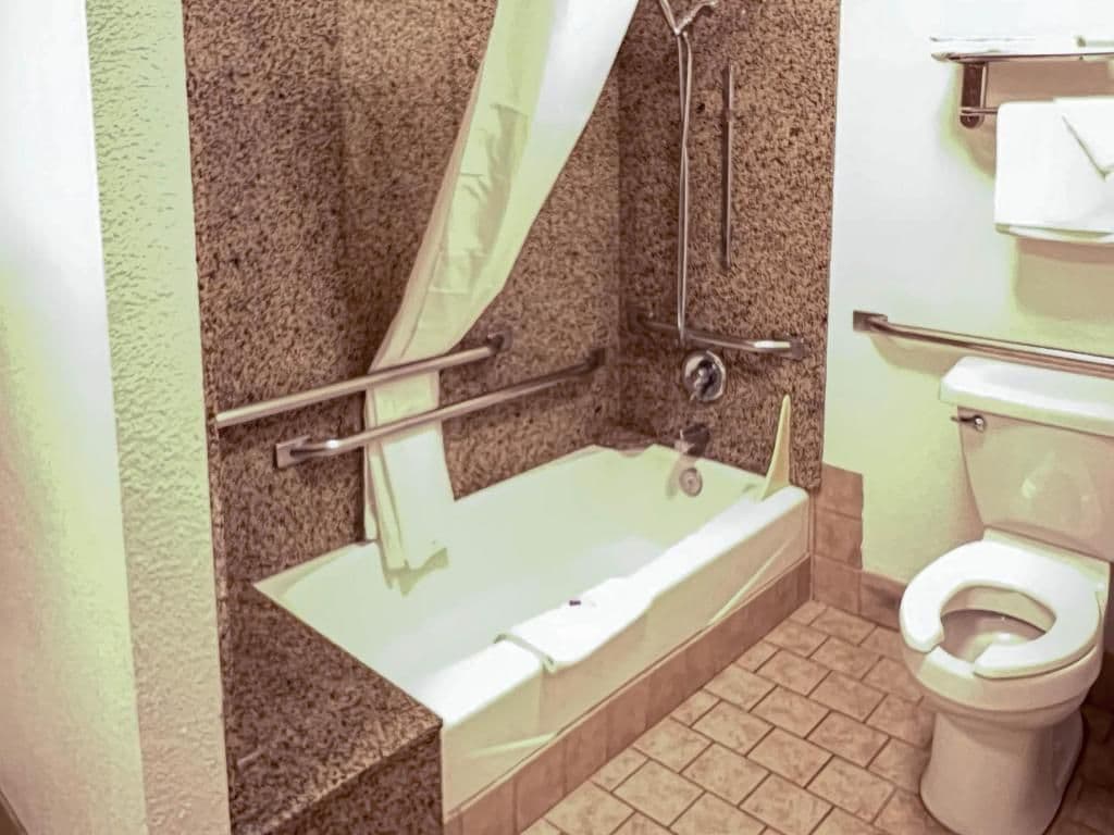 A bathroom with a bathtub, toilet, and shower.
