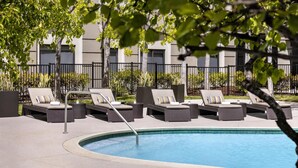 Un área junto a la piscina con sillones de descanso y una piscina.