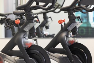 Bicicletas estáticas con manubrios y palancas rojas, probablemente para ejercicios en interiores.