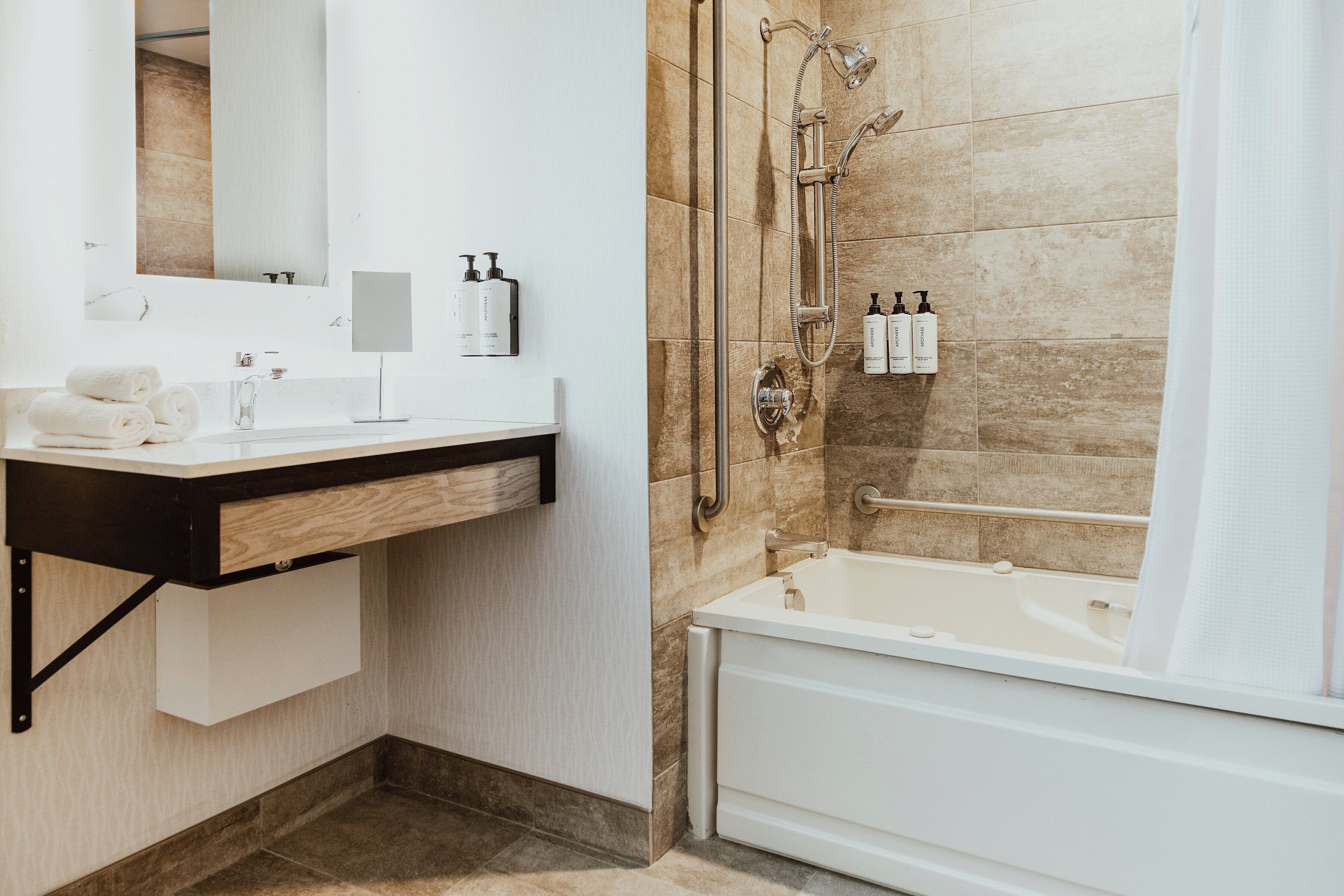Une salle de bain moderne avec un lavabo blanc, un miroir et une baignoire.