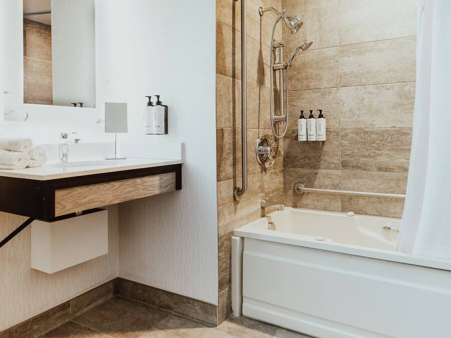 Une salle de bain moderne avec un lavabo blanc, un miroir et une baignoire.