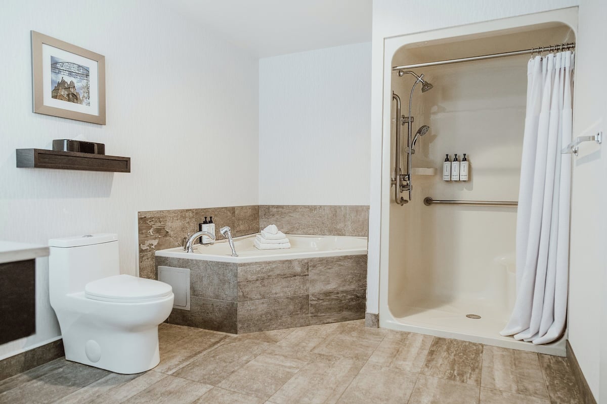 A bathroom with a toilet, sink, bathtub, and shower.
