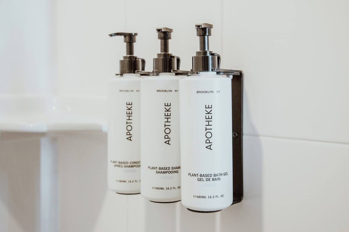 Three bottles of Apothéke plant-based shampoo and bath gel.
