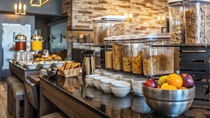 Un bufé de desayuno con diversos alimentos y recipientes.