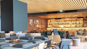 Un área de descanso moderna con asientos, chimenea y bar con una variedad de botellas.