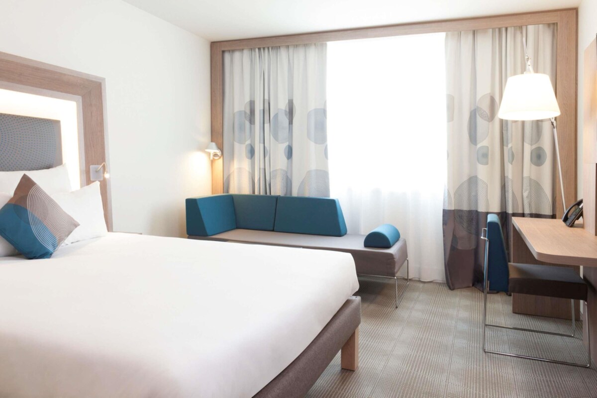 Una habitación de hotel con una cama grande, un sofá, un escritorio y una silla.