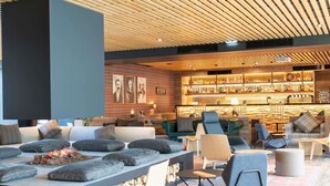 Un área de descanso moderna con asientos, chimenea y bar con una variedad de botellas.