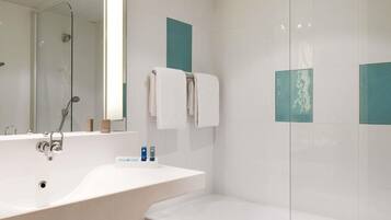 Une salle de bain moderne avec un grand lavabo, un miroir, une douche en verre et une baignoire.