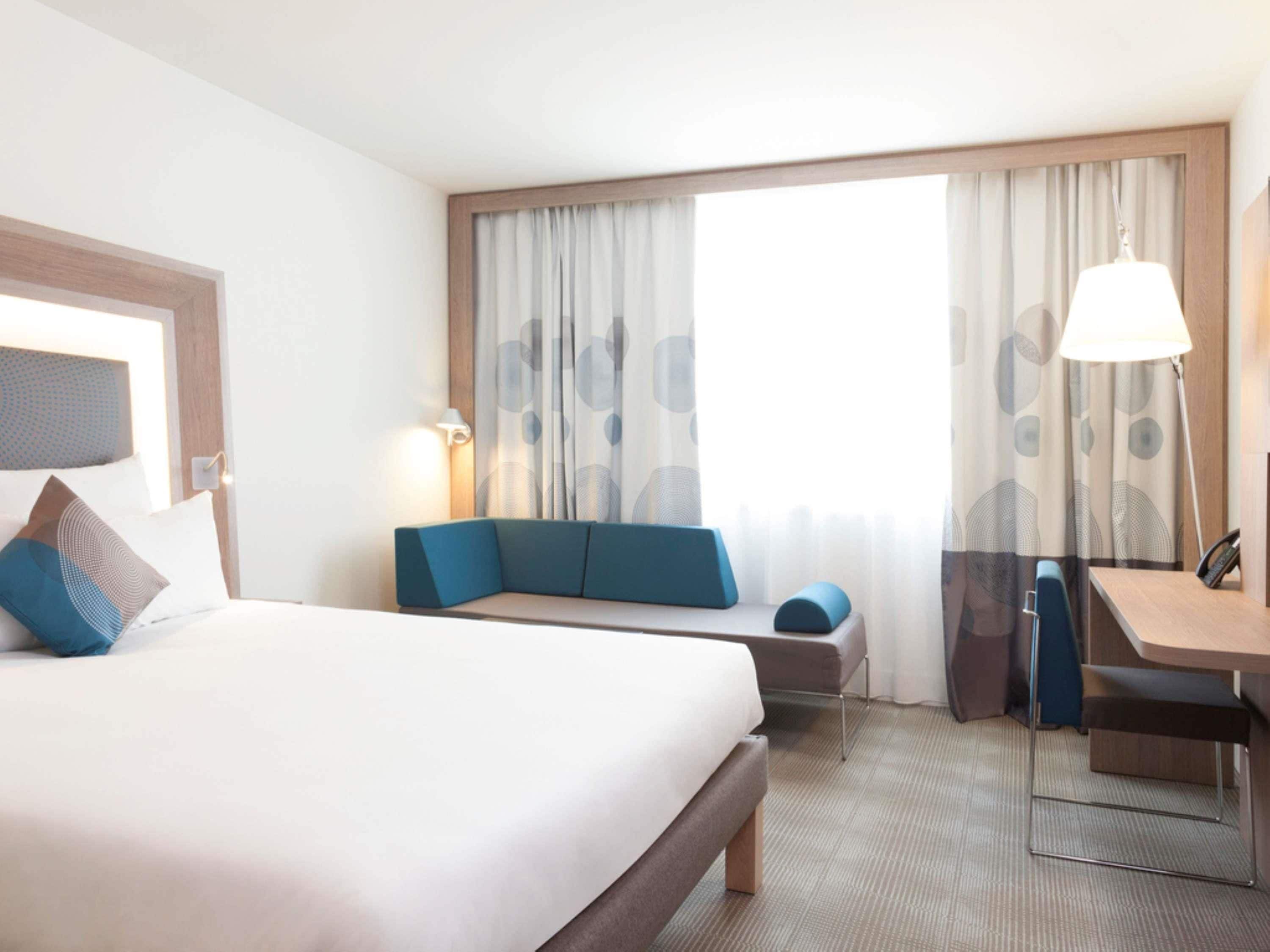 Ein Hotelzimmer mit einem großen Bett, einer Couch, einem Schreibtisch und einem Sessel.