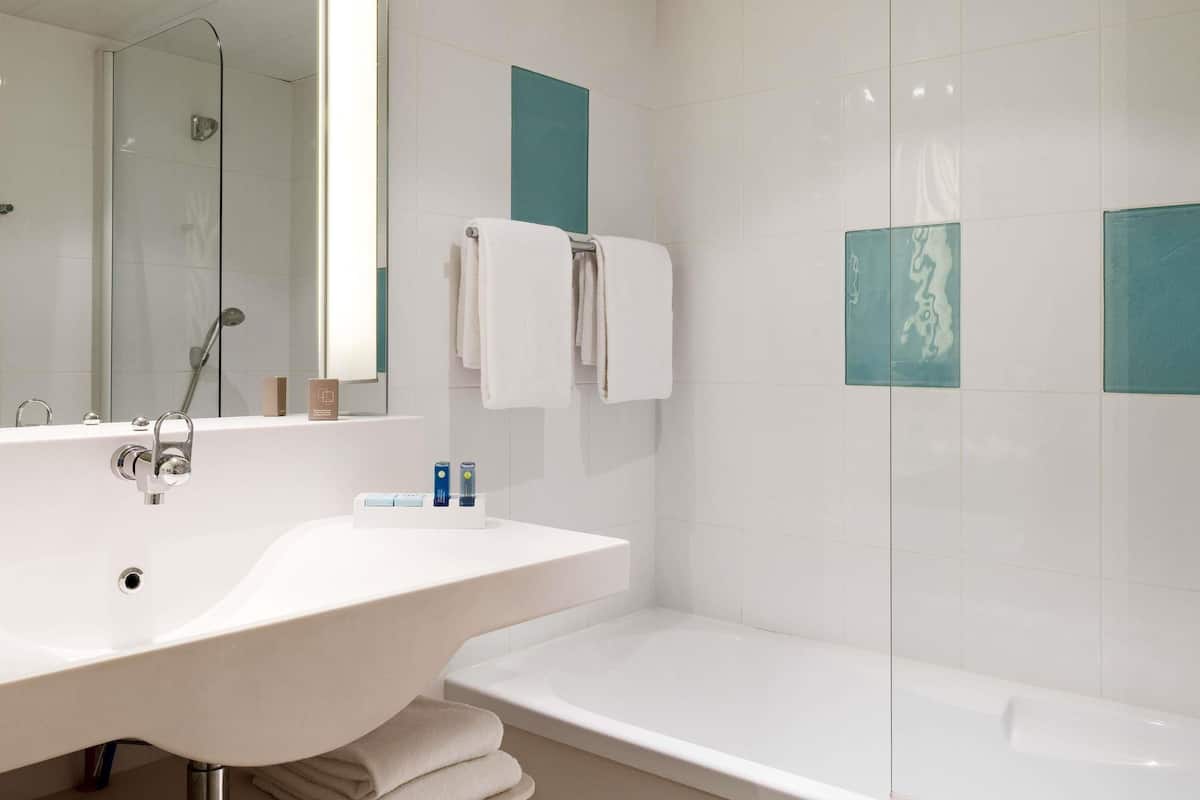 Bathtub, eco-friendly toiletries, hair dryer, towels