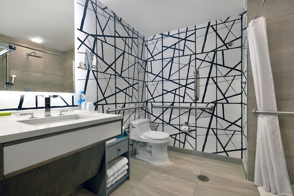 A modern bathroom with a white sink, a toilet, and a shower area. - Le Meridien St. Louis Downtown (St. Louis)