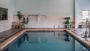 An indoor swimming pool with clear depth markings, a ceiling fan, and potted plants. - Quality Inn - Niagara Falls Blvd (Niagara Falls)