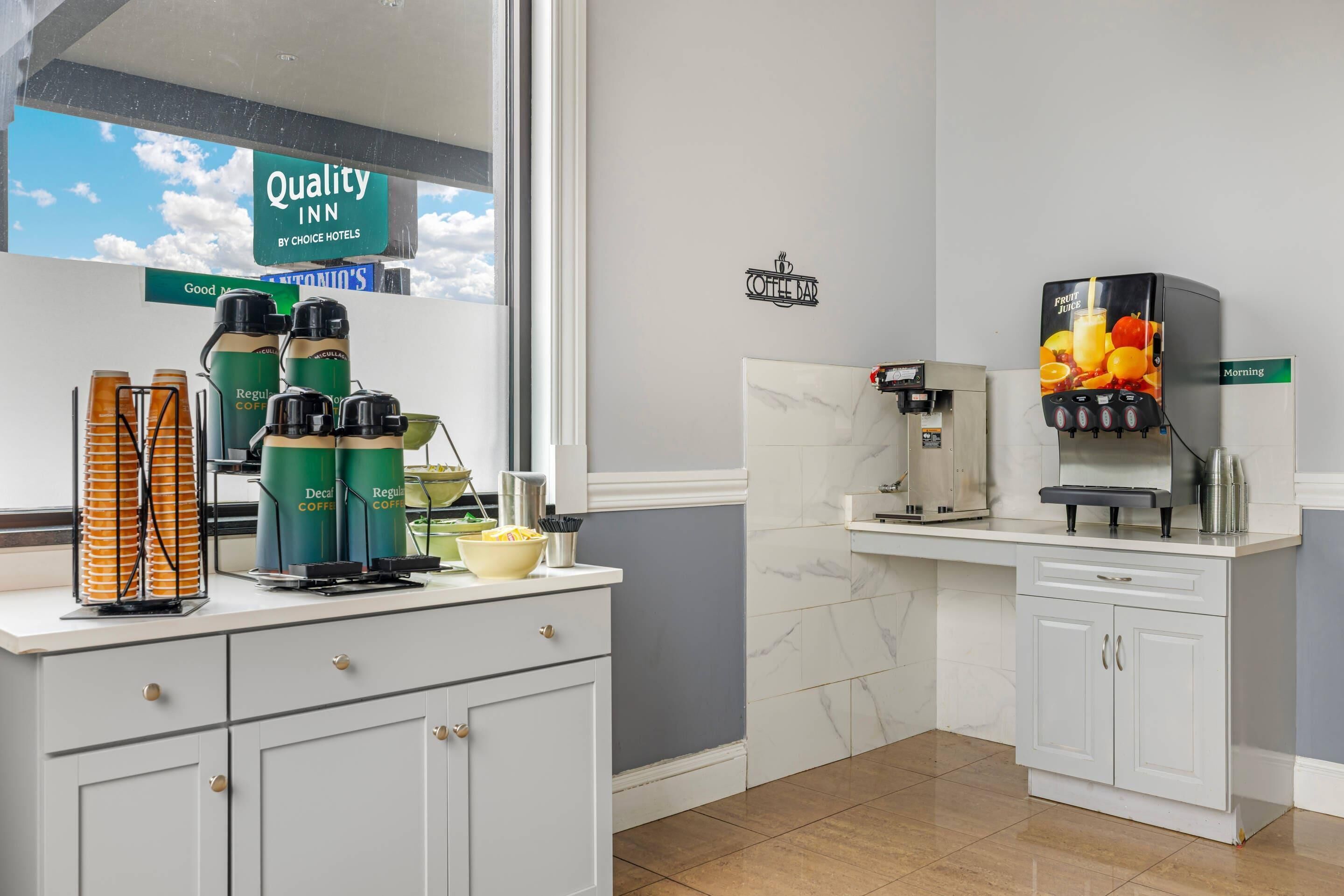 A hotel kitchen with coffee machines, a coffee bar, and a view of the sky.