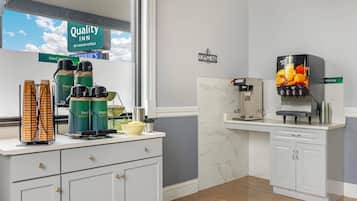 A hotel kitchen with coffee machines, a coffee bar, and a view of the sky.