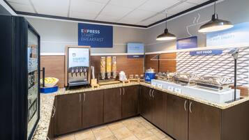 A breakfast area with a self-serve station, including a coffee machine and various food options.