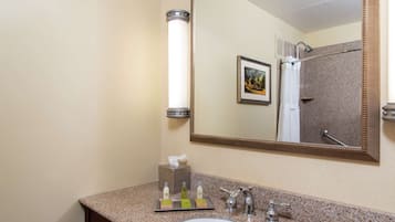 A bathroom with a sink, mirror, towel rack, and a framed picture on the wall.
