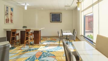Una sala de conferencias con alfombra estampada, una pizarra y un ventanal con vistas.