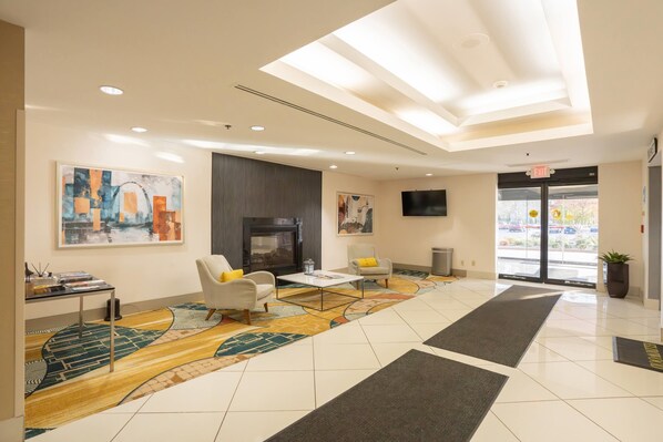 A modern lobby with a fireplace, seating area, and artwork on the walls.