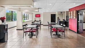 Un espace repas moderne, doté de plusieurs tables et chaises, d’un distributeur d’eau et d’un panneau indiquant que le Wi-Fi est disponible gratuitement.