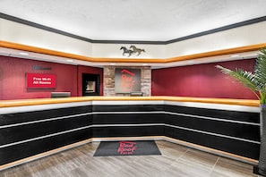 A hotel reception area with a modern design, including a reception desk, a 'Free Wi-Fi All Rooms' sign, and a 'Red Roof Inn' sign. - Red Roof Inn Hot Springs (Hot Springs)